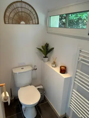 a bathroom with a white toilet and a window at Échappée Mistral - Détente Jacuzzi privé & Brasero in Eyragues