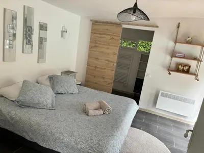 a bedroom with a bed with a stuffed animal on it at Échappée Mistral - Détente Jacuzzi privé & Brasero in Eyragues
