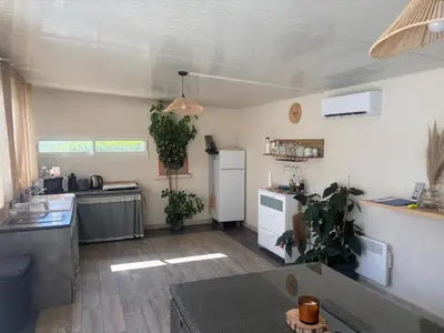 a kitchen with a white refrigerator and a table at Échappée Mistral - Détente Jacuzzi privé & Brasero in Eyragues