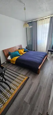 a bedroom with a large bed and wooden floors at Joli apparemment Attention un dégât des eaux en plafonds des WC et salle de bain mais tout fonctionnelle in Salon-de-Provence