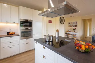 a kitchen with white cabinets and a bowl of fruit on the counter at L'Oliveraie in Saint-Saturnin-les-Apt
