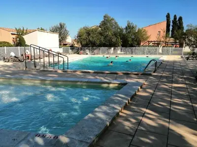 a swimming pool with people in the water at chez bruno et marie jo in Saint-Saturnin-lès-Avignon