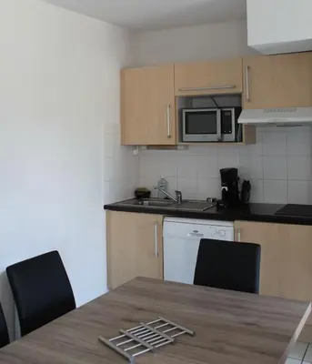 a kitchen with a table and chairs and a microwave at chez bruno et marie jo in Saint-Saturnin-lès-Avignon