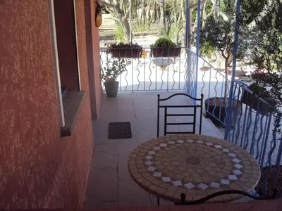 a patio with a table and chairs on a porch at La Douloire in Pernes-les-Fontaines