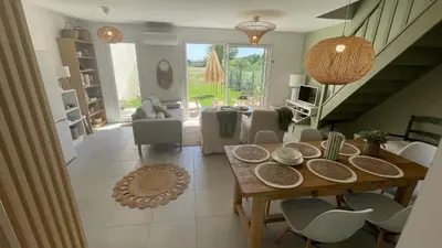 a dining room with a wooden table and white chairs at Maison Le Clos Du Moulin 3 - Climatisée, jardin & parking gratuit - 3 chambres doubles - 10 min Avignon in Entraigues-sur-la-Sorgue