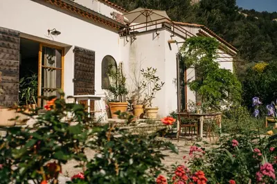 a garden in front of a house with flowers at Hidden gem with panoramic views in Fontaine-de-Vaucluse