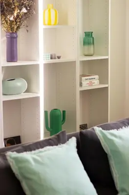 a living room with a couch and shelves with vases at Casëto Luberon in Apt