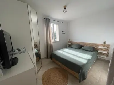 a small bedroom with a bed and a mirror at Le Lourmarinois in Lourmarin