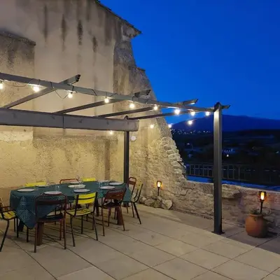 a table and chairs on a patio at night at Mon Ventoux in Modène
