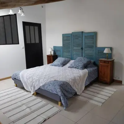 a bedroom with a large bed with blue shutters at Mon Ventoux in Modène