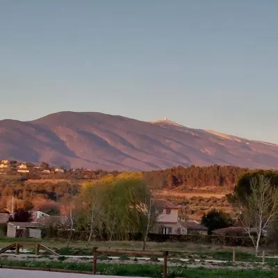 a field with a mountain in the background with a fence at Mon Ventoux in Modène