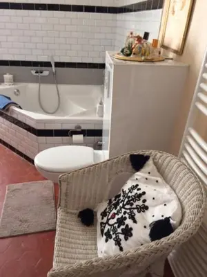 a bathroom with a toilet and a chair with a pillow at La Bégude des Alpilles in Orgon