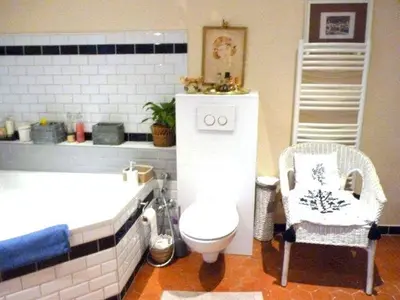a bathroom with a toilet and a tub and a chair at La Bégude des Alpilles in Orgon