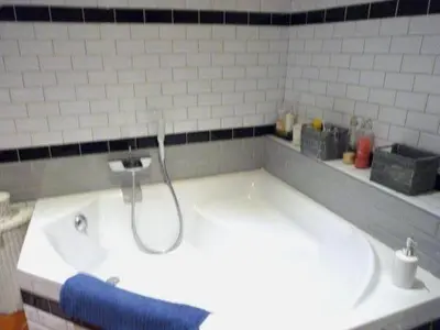 a large white bath tub with a blue towel at La Bégude des Alpilles in Orgon