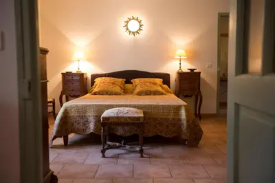 a bedroom with a bed and a clock on the wall at Luberon - Mas du Grand Saint Julien in Rustrel