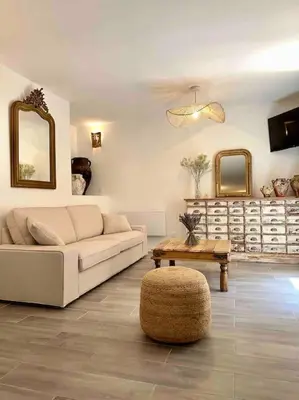 a living room with a couch and a table and mirrors at Lou Paseo : Appartement Brocante centre historique in LʼIsle-sur-la-Sorgue