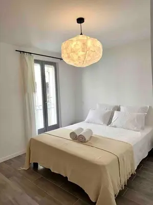 a bedroom with a large bed with a large window at Lou Paseo : Appartement Brocante centre historique in LʼIsle-sur-la-Sorgue
