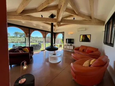 a living room with leather furniture and wooden ceilings at Petite Toscane Villa close to Aix en Provence in Ventabren