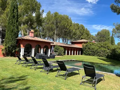 a group of chairs sitting in the grass next to a pool at Petite Toscane Villa close to Aix en Provence in Ventabren