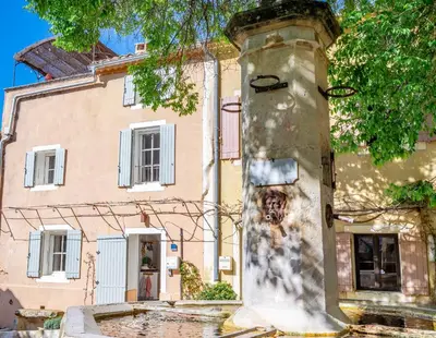 a building with a pillar with a painting on it at Chez Prunelle in Flassan