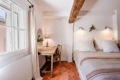 a bedroom with a bed and a desk with a window at Chez Prunelle in Flassan