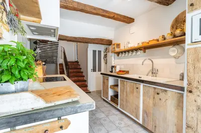 a kitchen with wooden cabinets and a sink at Chez Prunelle in Flassan