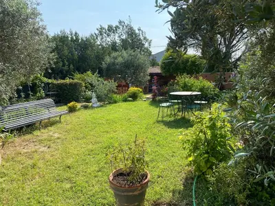 a garden with a bench and a table and chairs at Résidence Soleado Maison jumelée à 800m du centre ville de Bédoin in Bédoin