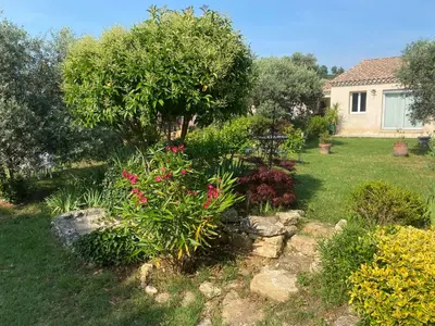 a garden with flowers and trees and a house at Résidence Soleado Maison jumelée à 800m du centre ville de Bédoin in Bédoin