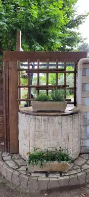 a wooden fence and some plants on a stone wall at Mas provençal in Sénas