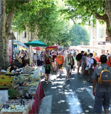 a crowd of people walking around an outdoor market at Le logis du Ventoux in Bédoin