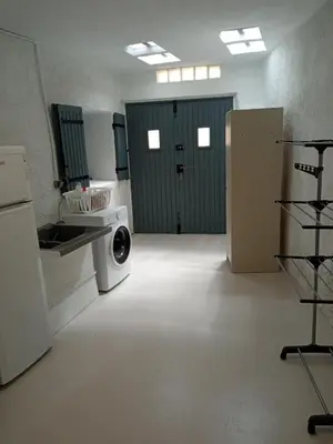 a laundry room with a washing machine and green doors at Le logis du Ventoux in Bédoin