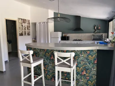 a kitchen with two bar stools and a counter top at Mas Paolo Gite de charme en Provence Piscine in Le Thor