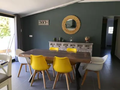 a dining room with a wooden table and yellow chairs at Mas Paolo Gite de charme en Provence Piscine in Le Thor