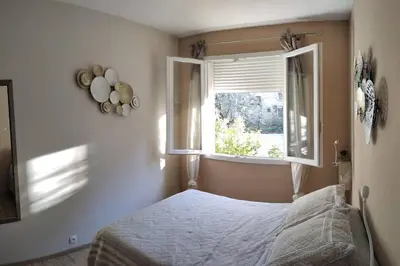 a bedroom with a bed and a window at Le Mas des Cigales avec parc et grande piscine in Velleron