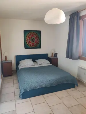 a bedroom with a bed with a blue comforter at Soleil bleu in Rognes