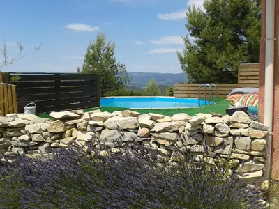 a stone retaining wall next to a swimming pool at Soleil bleu in Rognes