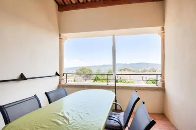 a table and chairs in a room with a large window at Village Pont Royal en Provence - maeva Home - Appartement climatisé 3 pièces 4 personnes - Prestige - super Home MAE-7124 in Mallemort