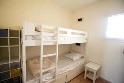 two bunk beds in a room with a window at Village Pont Royal en Provence - maeva Home - Appartement climatisé 3 pièces 4 personnes - Prestige - super Home MAE-7124 in Mallemort