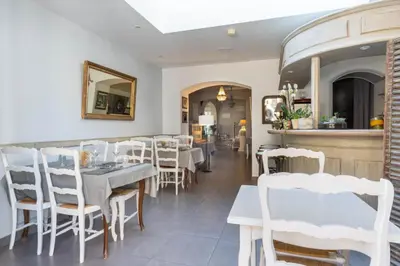 a dining room with white tables and chairs at Demeures et Châteaux Hôtel L'Hermitage in Pernes-les-Fontaines