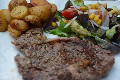 a plate of food with a steak and a salad at Demeures et Châteaux Hôtel L'Hermitage in Pernes-les-Fontaines