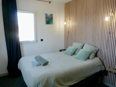 a bedroom with a bed with pillows and a window at Joli Studio le clos d'Aix avec grande terrasse piscine et parking gratuit in Aix-en-Provence