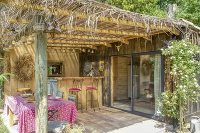 a wooden house with a table and chairs on a patio at Vent de Bohème in Cabannes