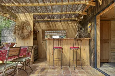 a kitchen with a bar with stools at Vent de Bohème in Cabannes