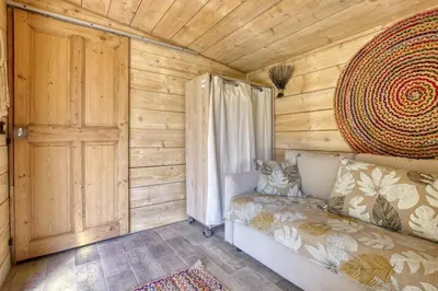 a log cabin with a couch and a window at Vent de Bohème in Cabannes