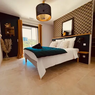 a bedroom with a large bed with a large mirror at Gite La Madeleine du Luberon. in Lioux