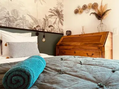 a bedroom with a bed with a blue blanket on it at Gite La Madeleine du Luberon. in Lioux