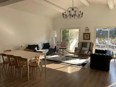 a living room with a table and a couch at Villa climatisée avec piscine à St Remy in Saint-Rémy-de-Provence