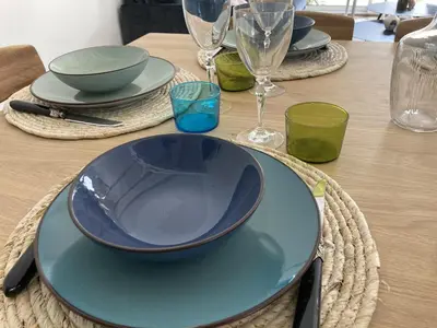 a table with a blue plate on a wooden table at Villa climatisée avec piscine à St Remy in Saint-Rémy-de-Provence