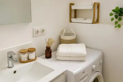 a bathroom with a sink and a washing machine at Maison, Jardin, piscine parking près d'Aix Centre in Venelles