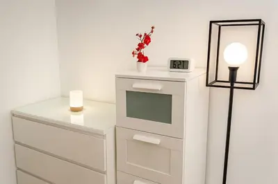 a white dresser with a clock and a lamp at Maison, Jardin, piscine parking près d'Aix Centre in Venelles
